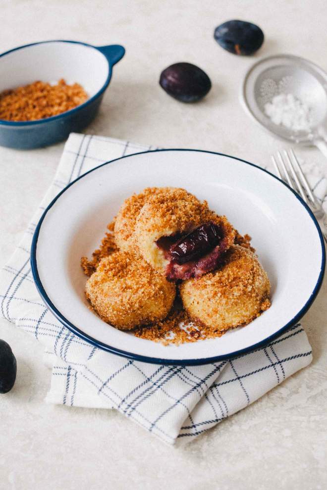 Plum dumplings with fried breadcrumbs served on a plate