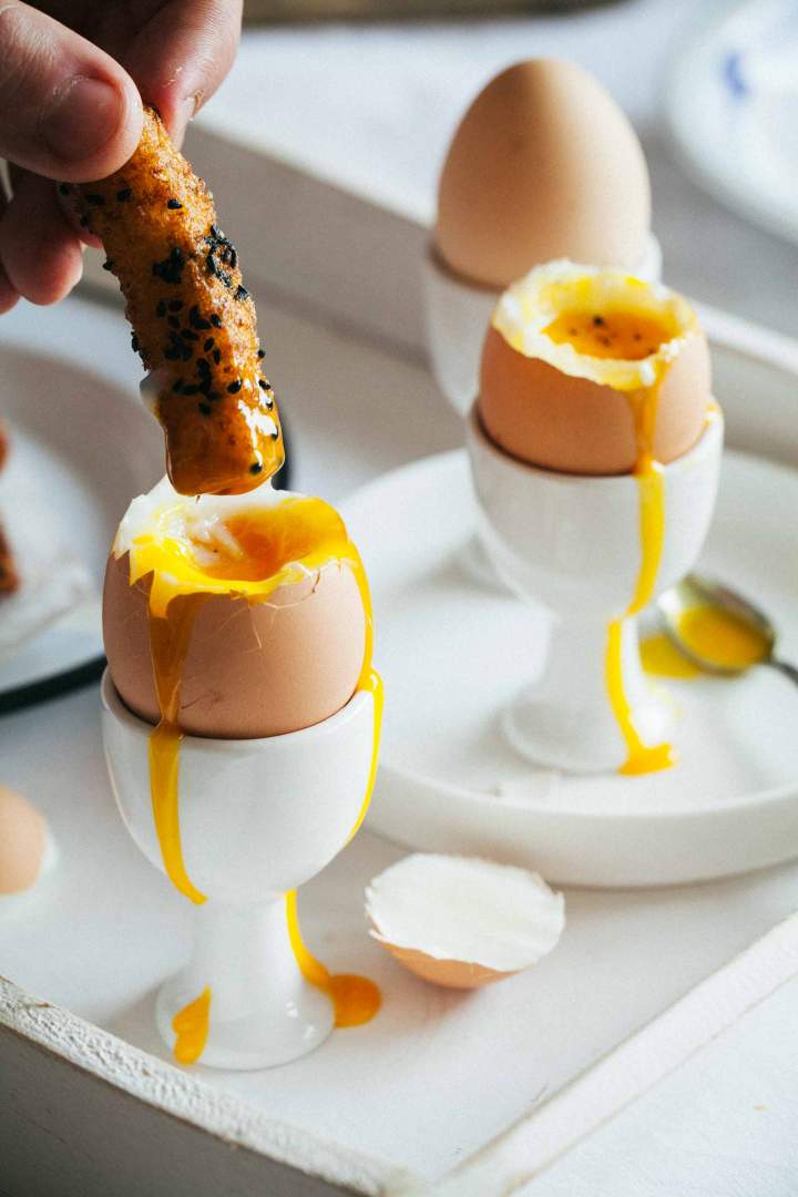 Dipping savory french toast into soft boiled eggs for breakfast