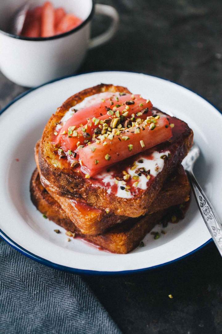 French toast with poached rhubarb and pistachios French toast with poached rhubarb and pistachios served on a plate