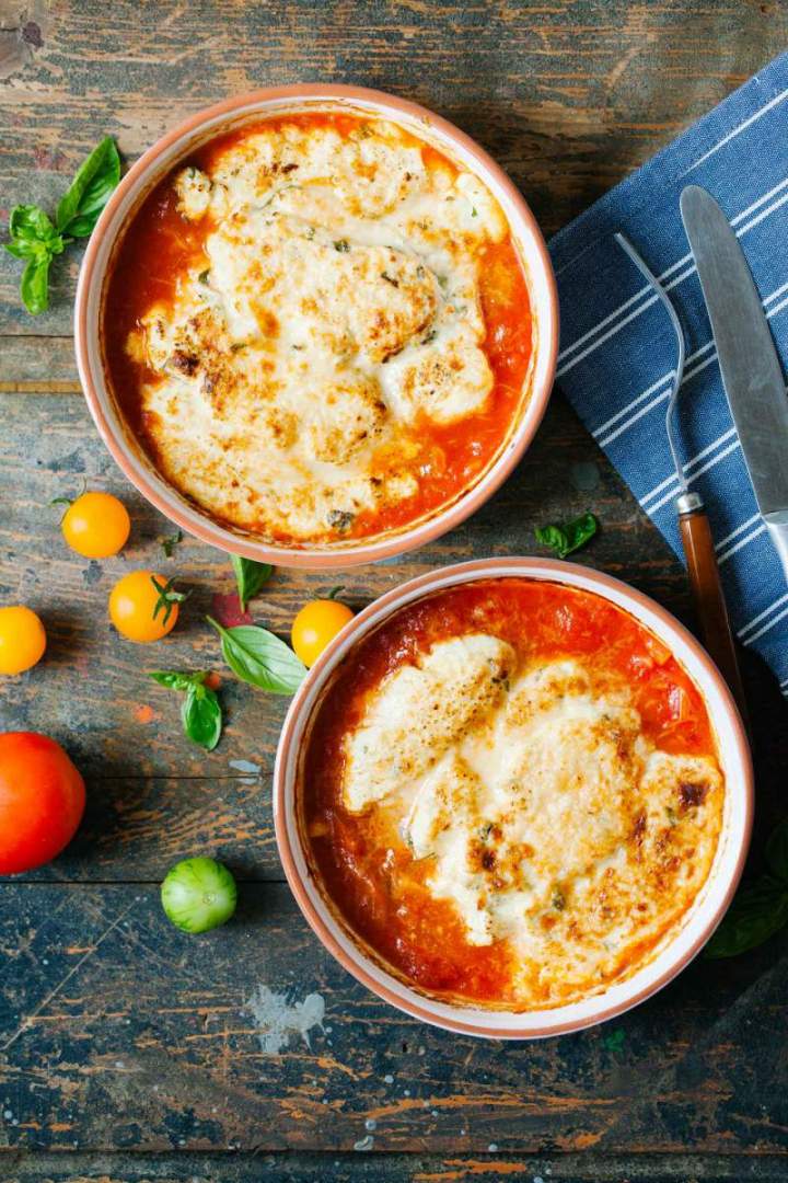 Herb dumplings gratin with tomato sauce served in bowls