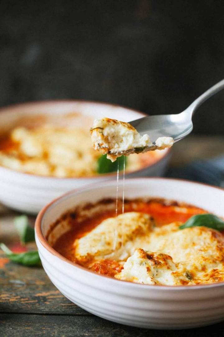 Herb dumplings gratin with tomato sauce and melting cheese