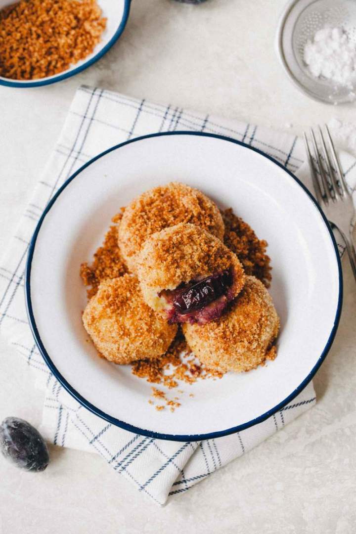 Plum dumplings with fried breadcrumbs served on a plate