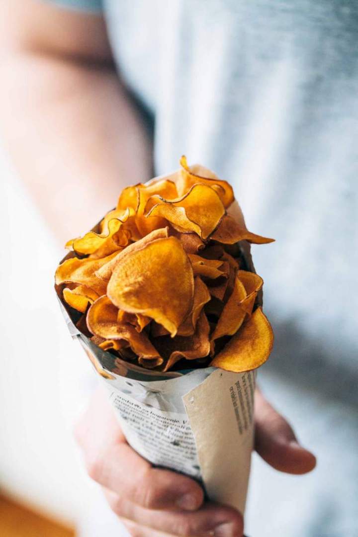 Sweet potato chips with rosemary salt in a paper bag
