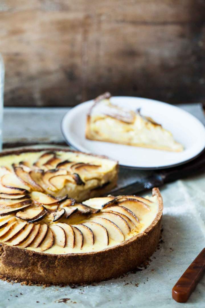 Apple tart with vanilla sauce sprinkled with icing sugar
