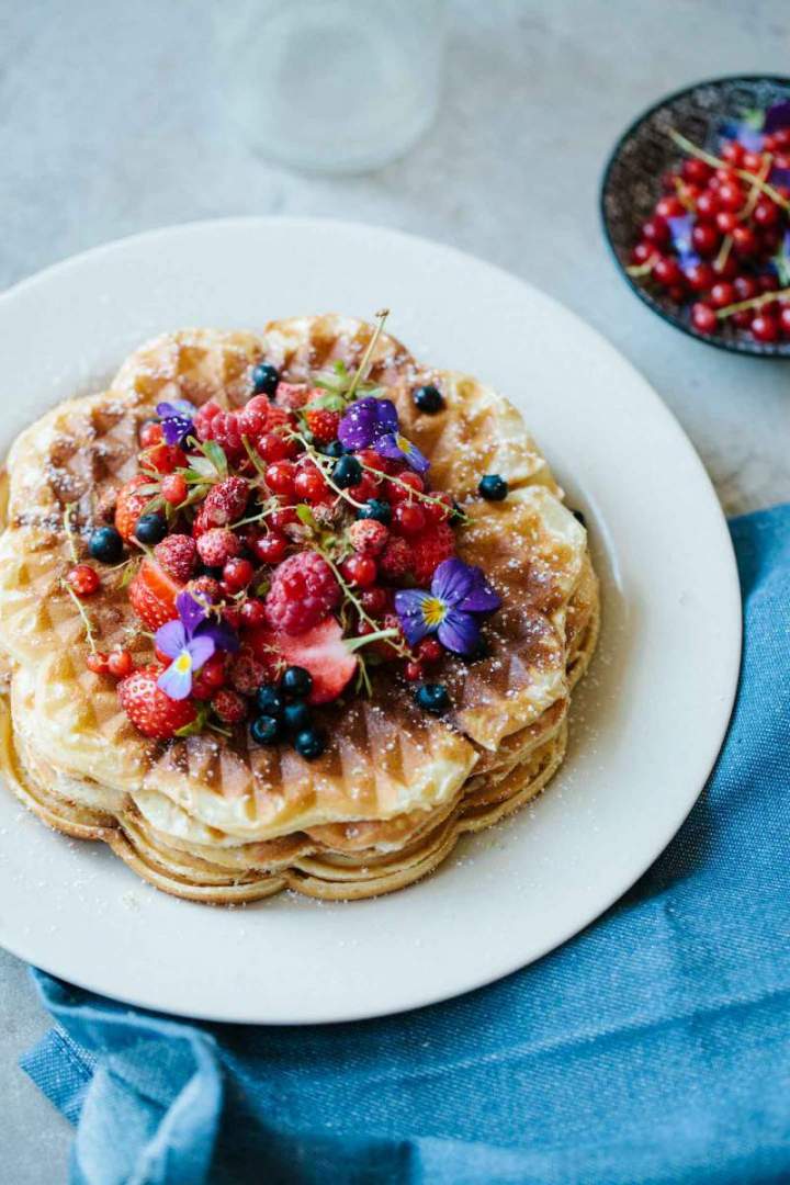 Crisp waffles served with berries and icing sugar