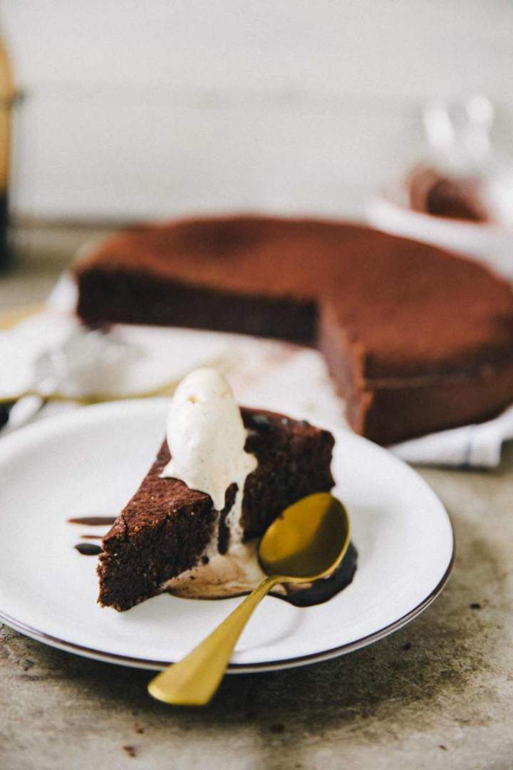 Slice of Flourless espresso chocolate cake served with ice cream and chocolate sauce