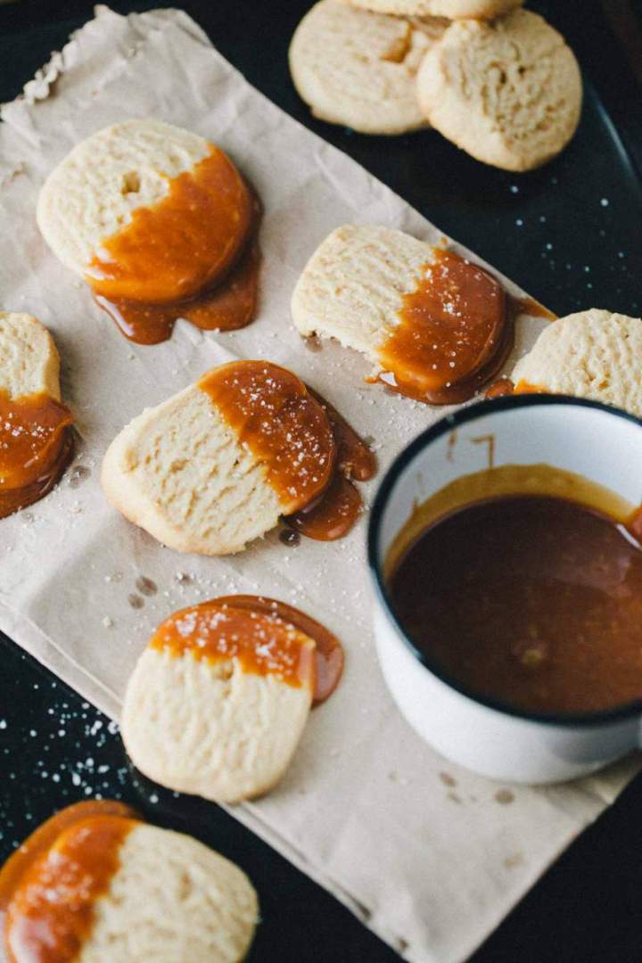 Peanut butter cookies dipped in salty caramel on a tray