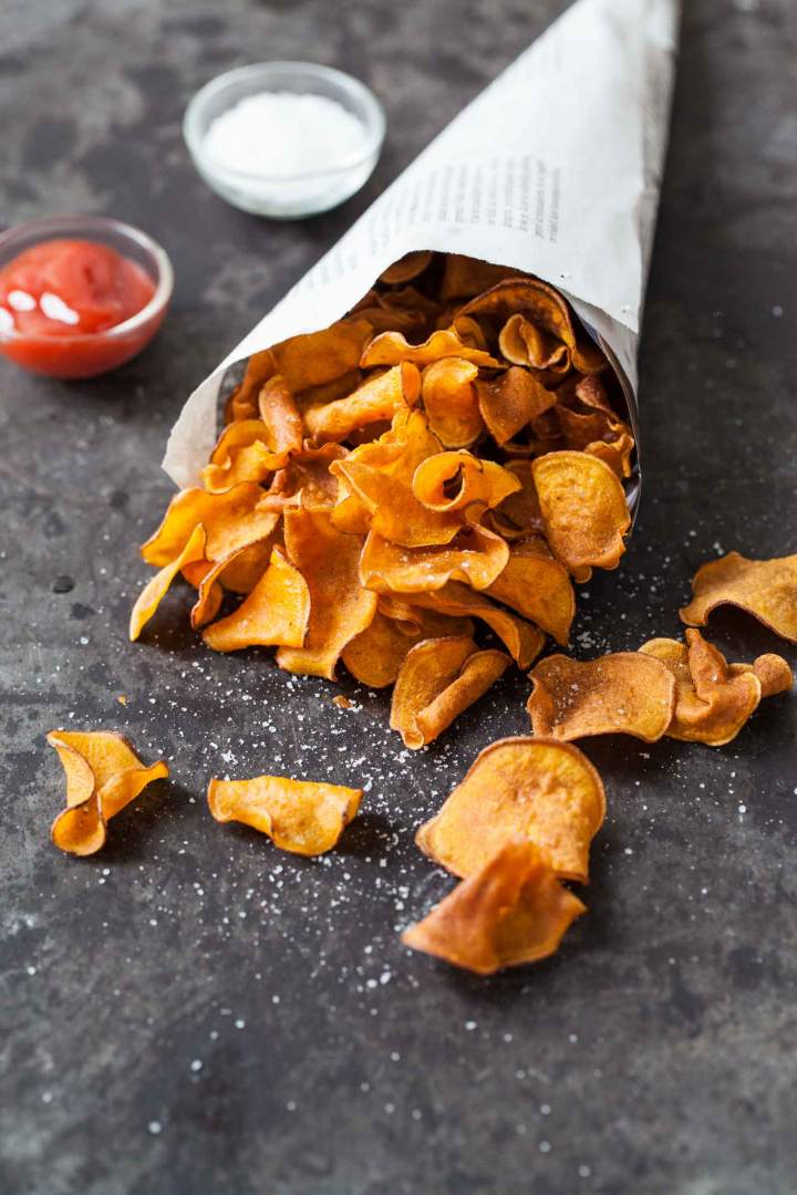 Sweet potato chips with rosemary salt in a paper bag